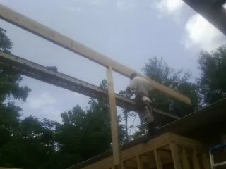 Carpenter setting a ridge beam over a new addition frame — Ice Dam Removal by Roofing Brothers in East Haddam