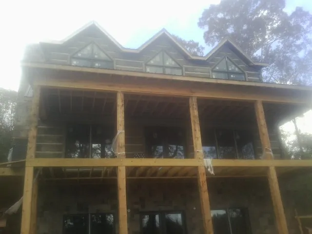Dormers and porch framing on a large log home under construction — Roof Coating work by our crew in East Haddam